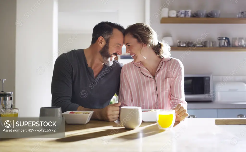 Happy couple, trust or eating breakfast together with love, diet or juice in meal in home kitchen. Romantic people, forehead or morning snack for bonding, support or food in healthy marriage for care