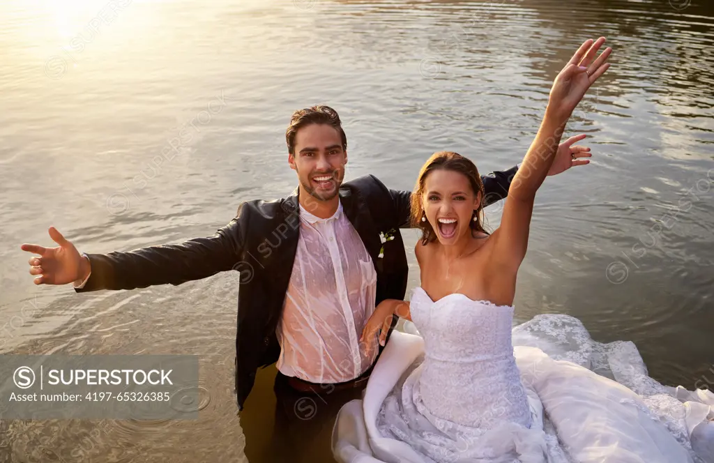 Lake, portrait of wet bride and groom standing in water together with excited smile and playful romance. Love, marriage and happy couple celebrate romantic, loving relationship and wedding in nature.