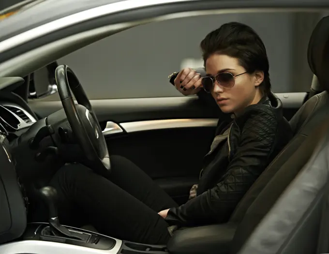 Woman, car and sunglasses while driving for a roadtrip commute in a stylish vehicle. Female person, vision and cool, fashion in a transportation motor for trip with confidence to travel destination