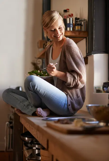 Happy, woman and eating salad in kitchen at home, nutrition and fresh leafy greens for healthy diet. Vegetables, bowl and smile of hungry person with food, lunch or organic vegan meal for wellness