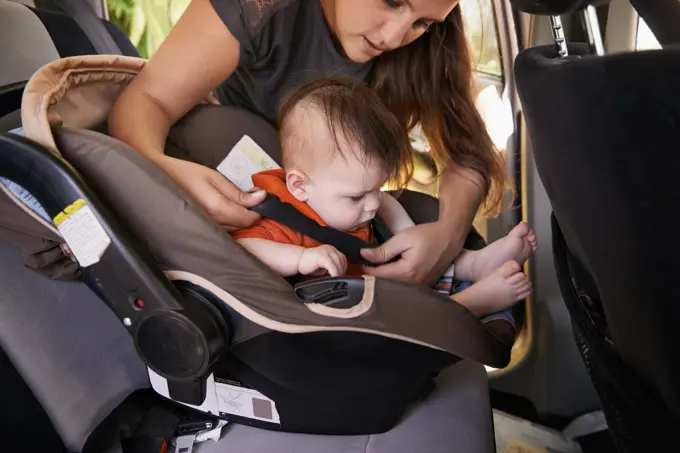 Mom, baby and car seat in motor vehicle for child safety with buckle or strap. Mother, infant and protection, travel and parenting for secure transport to fasten or latch with love and harness