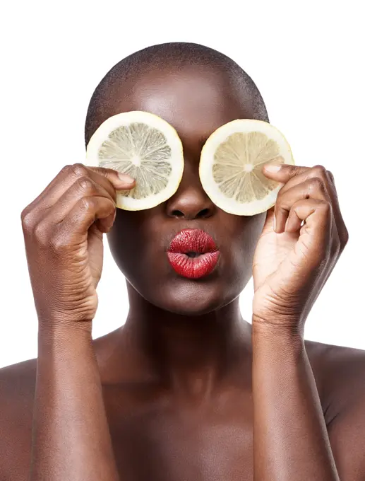 Black woman, kiss and lemon skincare in studio for organic dermatology routine, youth or wellness. White background, face and African model with facial fruit, diet food and eyes product for beauty