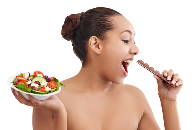 Happy woman, salad and chocolate with choice for diet, nutrition or healthy balance on a white studio background. Female person, brunette or model in decision for dessert or bowl of vegetables to eat