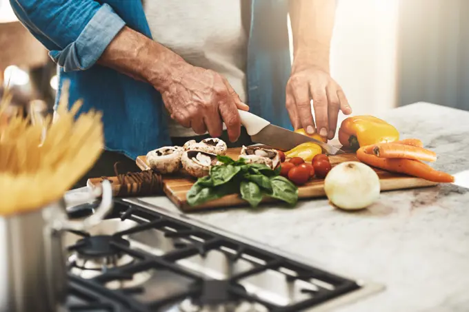 Cooking, hands and man cutting vegetables in the kitchen for diet, healthy or nutrition dinner. Recipe, closeup and mature male person from Canada chop ingredients for a supper or lunch meal at home.