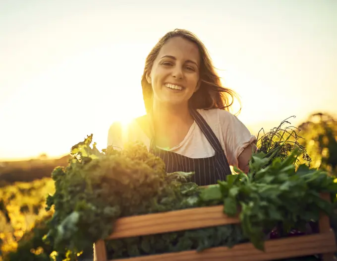 Portrait, farmer and vegetable harvest outdoor for natural diet, sustainability and vegan nutrition. Woman, agriculture and herbs in crate for growing food, environmental care or eating healthy