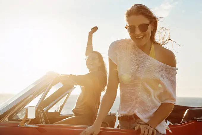 Car, portrait and people with travel by ocean for outdoor adventure, freedom or break in convertible. Happy, summer and friends with smile on road trip for holiday, sunset and tourism in Croatia