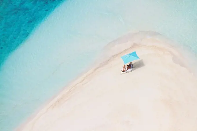 shot from jet of two people sunbathing on paradise beach