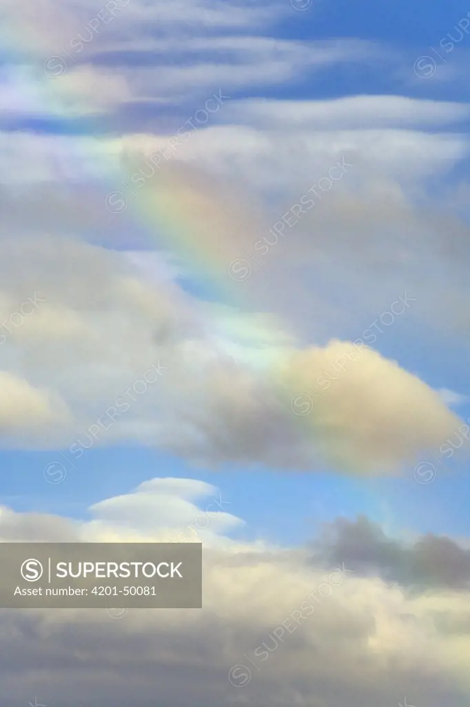 Rainbow colors among cumulus clouds on a fall evening, Lava Beds National Monument, California