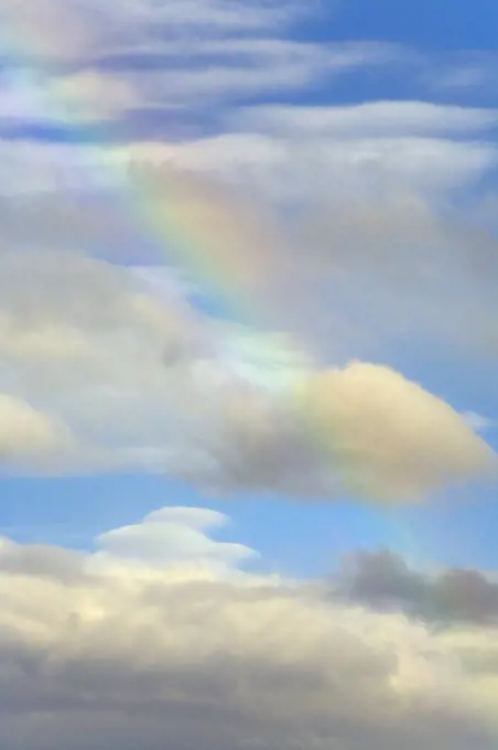 Rainbow colors among cumulus clouds on a fall evening, Lava Beds National Monument, California