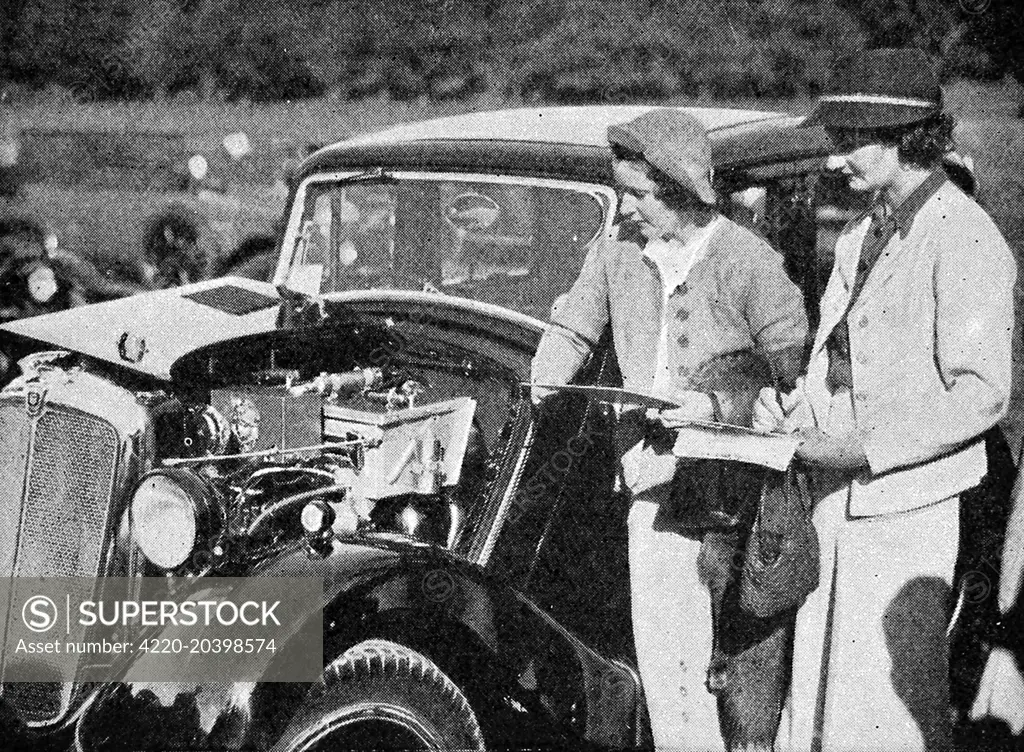 Kay Petre  (probably the best known female racing driver before the war), and E. Wisdom, another well known female racing motorist, seen  here judging in the coachwork competition at the Morris rally at Lilleshall.     Date: September 26th 1936