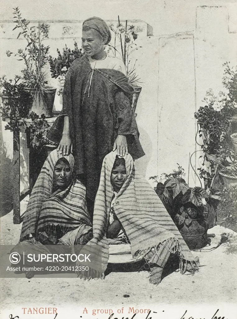 A Moorish man with two of his wives in an outdoor garden in Tangiers, Morocco     Date: 1905