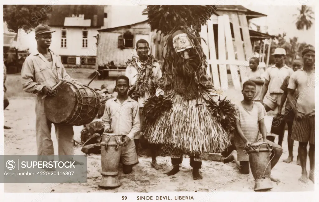 Liberia, West Africa - a 'Sinoe Devil' - a man in the ceremonial costume of the devil from the Sinoe Region of the country.     Date: circa 1910s