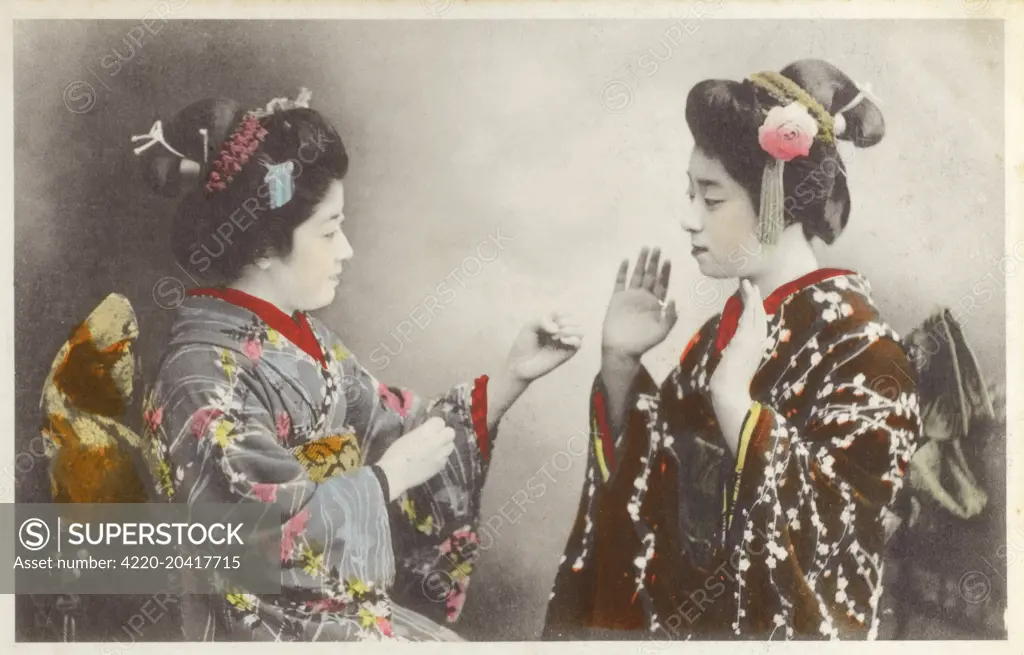 Japan - Geisha girls at play. They may be either mock fighting (the geisha on the left appears to have balled fists) or possibly playing scissors-paper-rock, which originated in Japan.     Date: circa 1910s