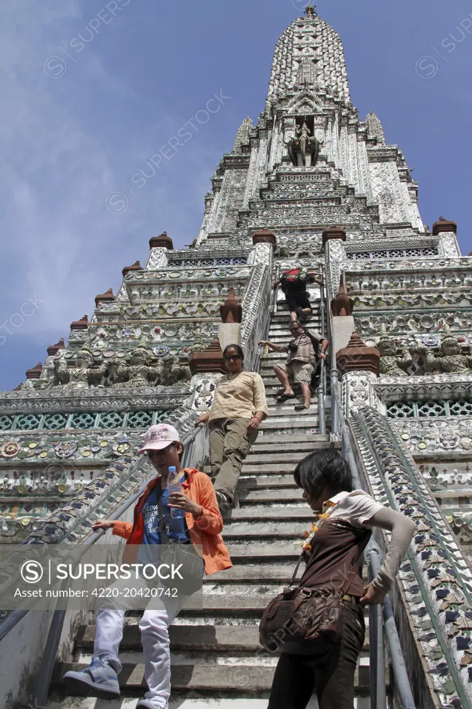 Tourists climbing a Chinese porcelain prang at Wat Arun, Temple of the Dawn in Bangkok, Thailand   Date: November 2010