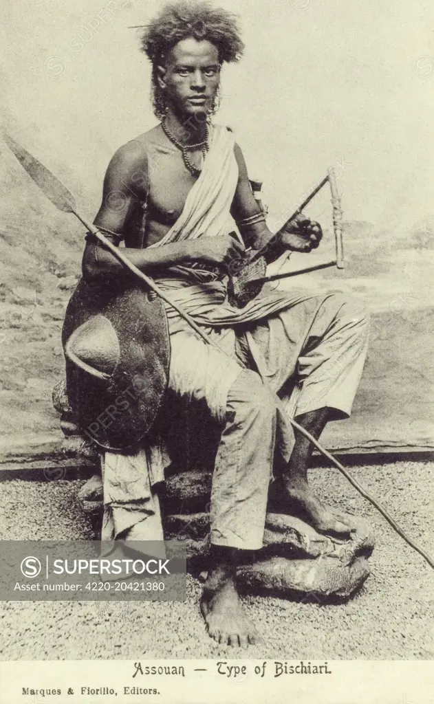 A Bisharin Tribesman of Aswan, Egypt with his shield, spear and small Egyptain lyre.     Date: circa 1910s