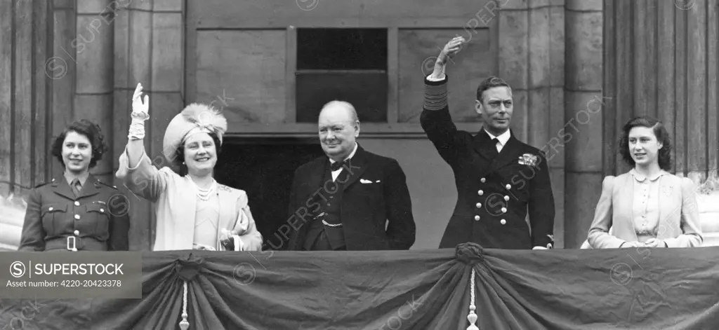 King George VI, Queen Elizabeth (later the Queen Mother) together with their daughters, Princess Elizabeth (later Queen Elizabeth II) in ATS uniform and Princess Margaret Rose, and Prime Minister, Winston Churchill, on the balcony of Buckingham Palace waving to crowds on VE Day, 8 May 1945.     Date: 1945