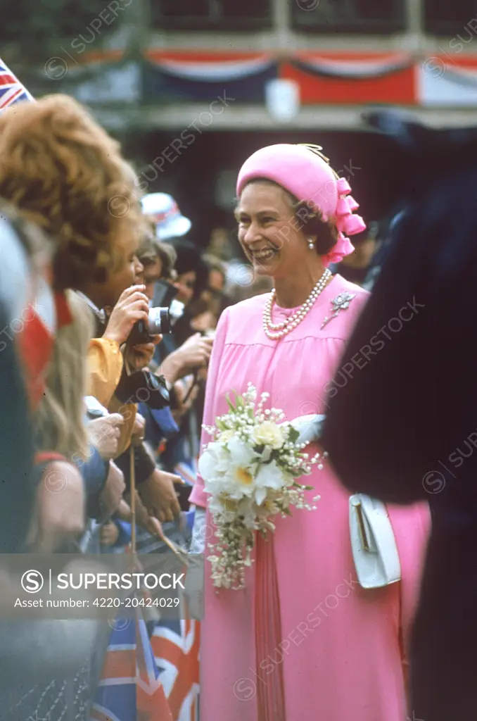 Queen Elizabeth II, a vision in pink smiles and chat with crowds of well wishers as she goes on a royal walkabout in London to celebrate the Silver Jubilee in 1977.  