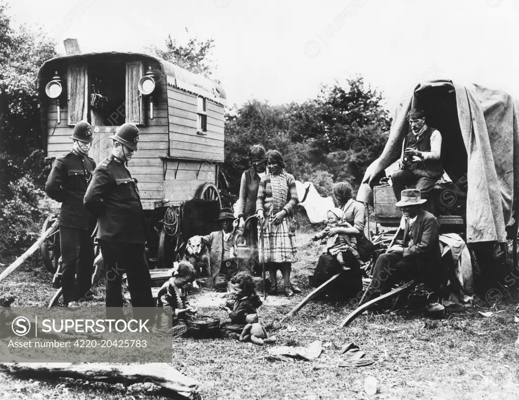 Two Policeman talk to a Gypsy family by their caravan and wagon on Epsom Downs     Date: circa 1920s