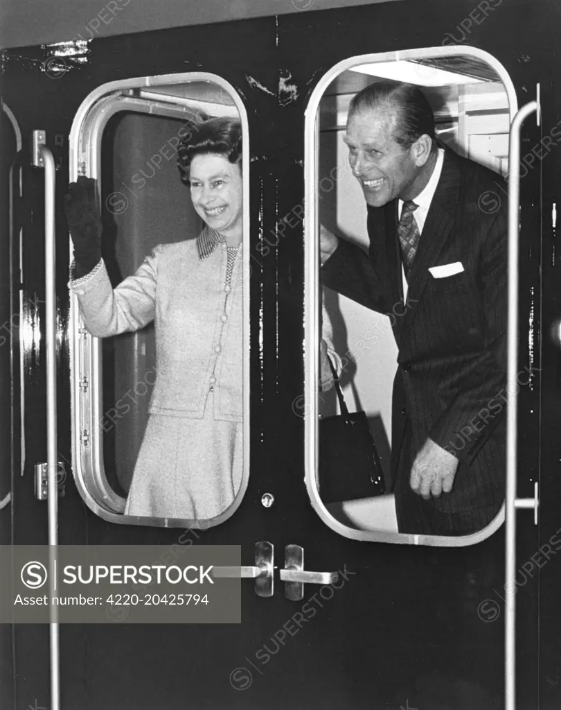 Queen Elizabeth II and the Duke of Edinburgh waving from a train in the year of the Silver Jubilee.       Date: 1977