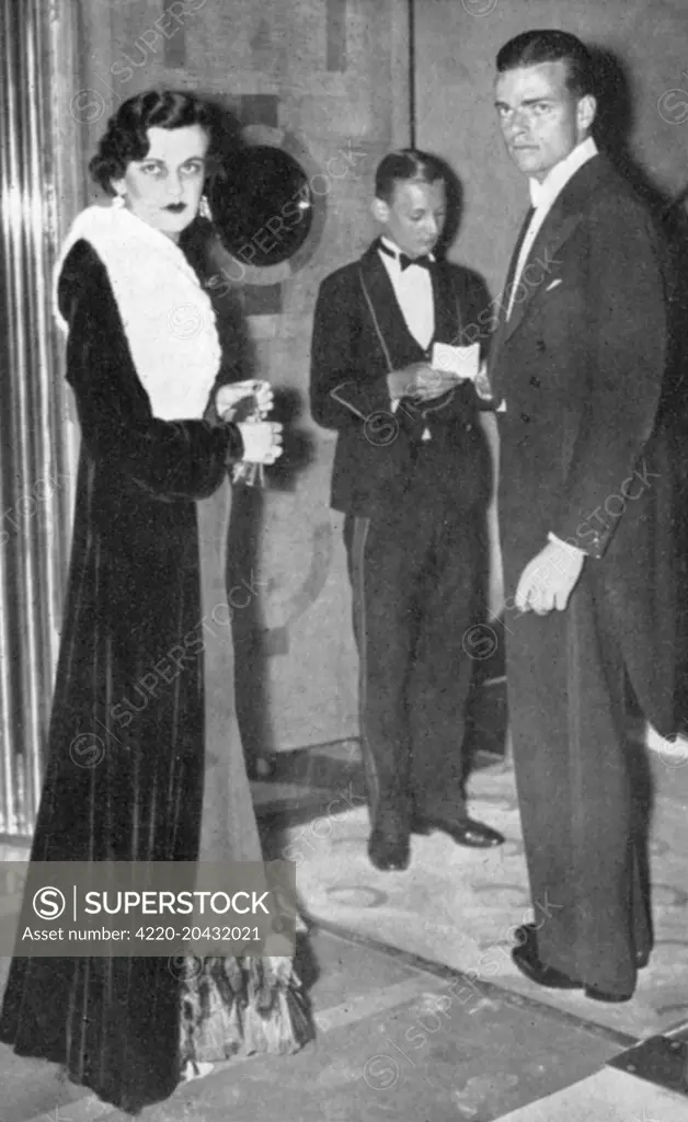 Mr and Mrs Charles Sweeny attending a gala presentation, in aid of the League of Mercy of 'The Princes of Wales' film.  Mrs Charles Sweeny was the former Miss Margaret Whigham, deb of the year in 1930.  Her second marriage made her Duchess of Argyll but the subsequent scandalous divorce case sullied her name.       Date: 1933