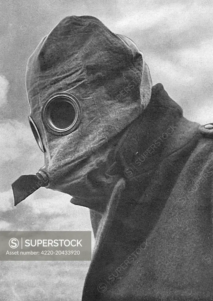 A 'fearsome-looking gas helmet'.  An example of a gas mask issued to British soldiers during the First World War.  The peculiar projection in front has its termination in the mouth so that the wearer inhales through the nose and exhales through the mouth and projecting tube, thereby avoiding condensation on the glasses of the goggles.     Date: 1916