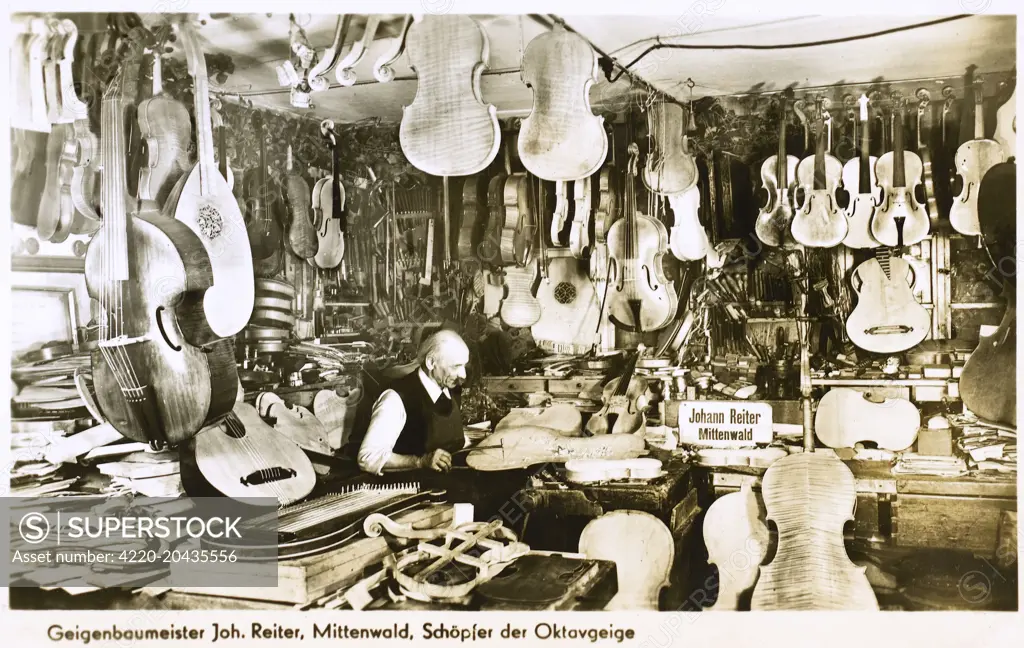 Musical instrument maker Johann Reiter of Mittenwald, Germany, surrounded by his wonderful creations, from lutes and cellos to violas and violins. A testament to the high art of carpentry and precision workmanship. The Reiter family have been involved in instrument making in Mittenwald, Germany for well over 100 years. The workshop was founded by Johann Baptiste Reiter (1834-1899), who studied violin-making with Johann Baader and Jean Vauchel, and won several medals and awards for violin-making.