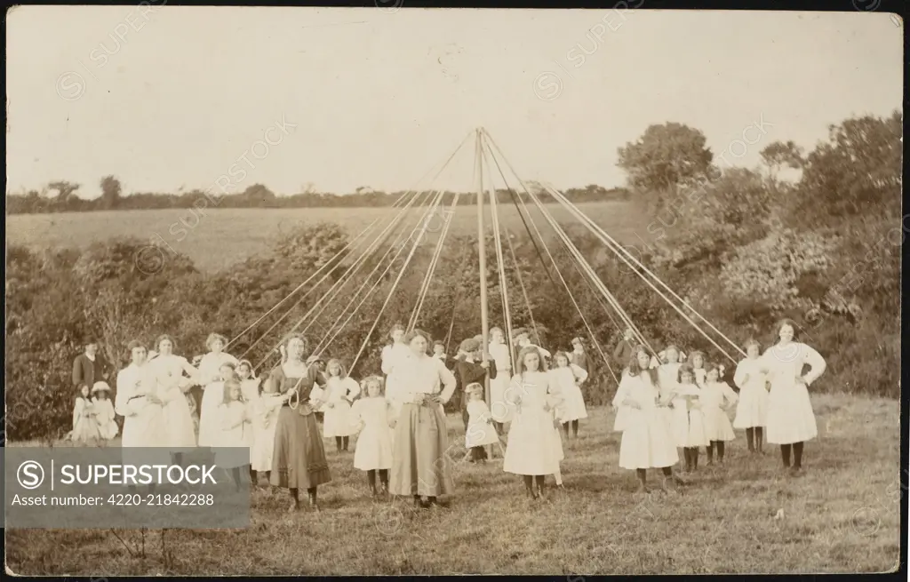 Children pose for the camera  before starting their dance in  an open field        Date: circa 1905
