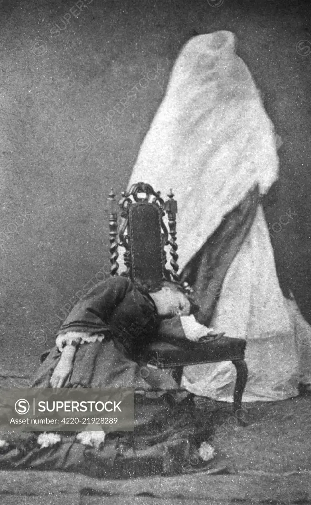 Florence Cook (c.1856-1904) was an English medium who claimed to materialise a spirit named Katie King. This photograph, taken during a seance at the house of William Crookes, shows Cook lying with her head on the seat of a chair, in a trance, with the spirit of Katie King hovering behind her.      Date: circa 1870s