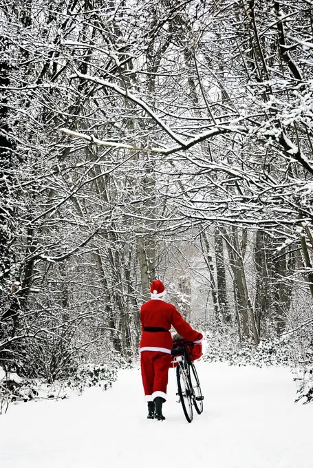 Father Christmas - in snow - with bicycle  