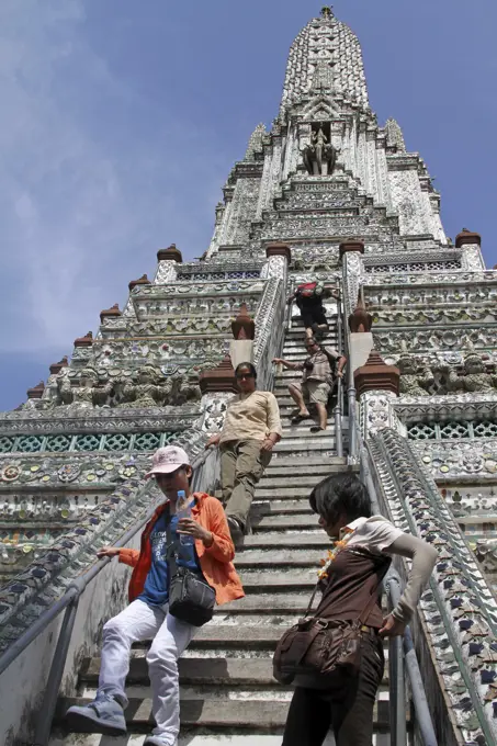 Tourists climbing a Chinese porcelain prang at Wat Arun, Temple of the Dawn in Bangkok, Thailand   Date: November 2010