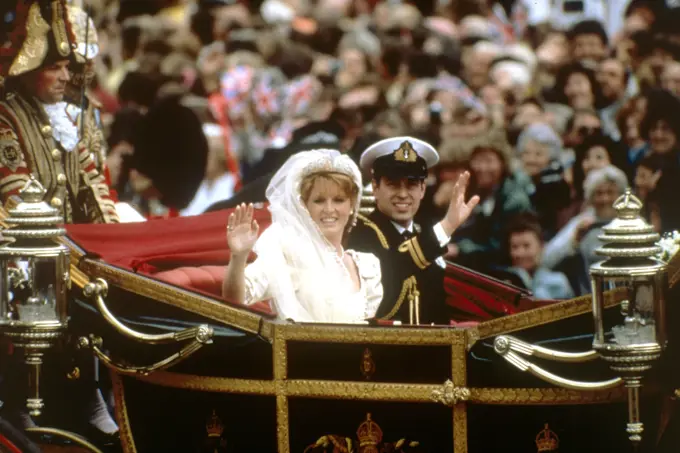 Prince Andrew, Duke of York, and his wife, Lady Sarah Ferguson, Duchess of York wave to the crowds lining the streets of London as they travel back to Buckingham Palace following their marriage at Westminster Abbey on 23 July 1986.     Date: 1986