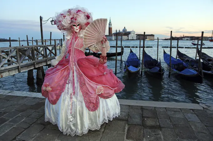 Woman wearing Venice Carnival Costume beside gondolas, Venice, Italy  2013