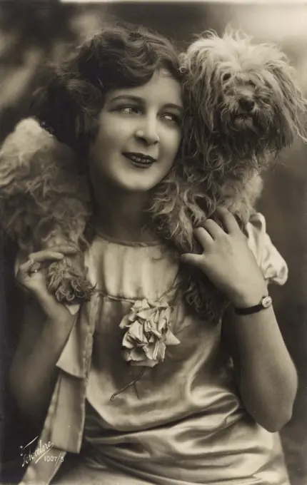 Studio portrait, young woman with a terrier dog wrapped round her neck.      Date: circa 1920s