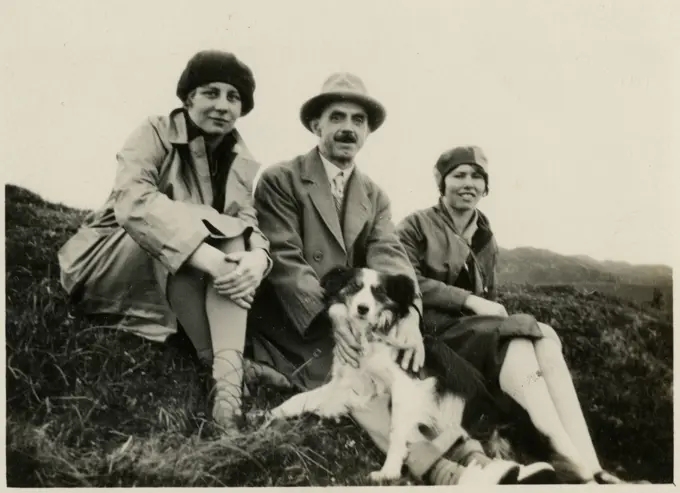 Three people out for a walk with a collie dog.      Date: circa 1930s