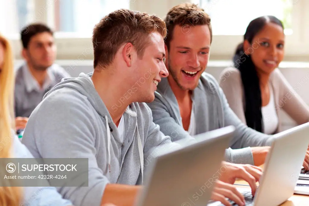 Two happy students chatting in university class