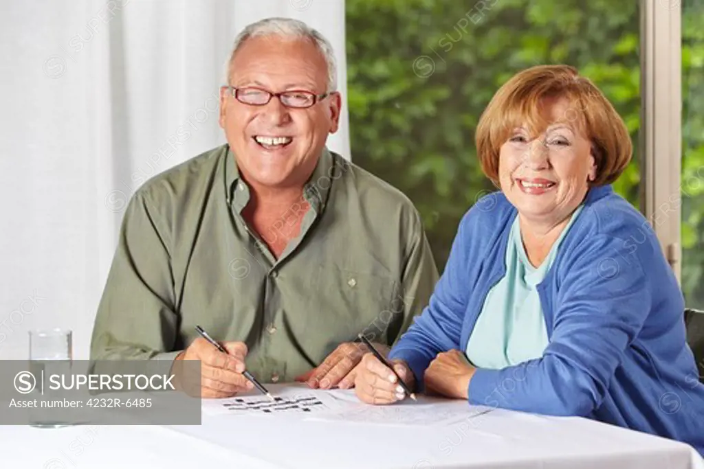 Two happy senior people solving riddles in a retirement home