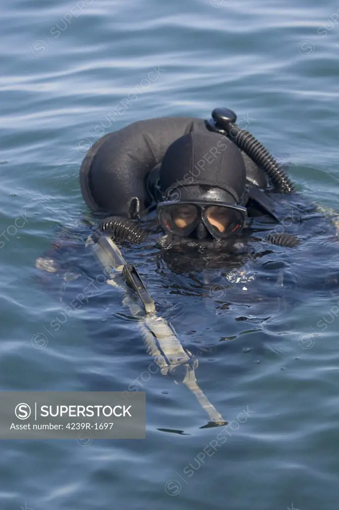 A Navy SEAL combat swimmer, diving a oxygen rebreather, taking a quick sneak and peak above the waterline to ensure he is on course to the target