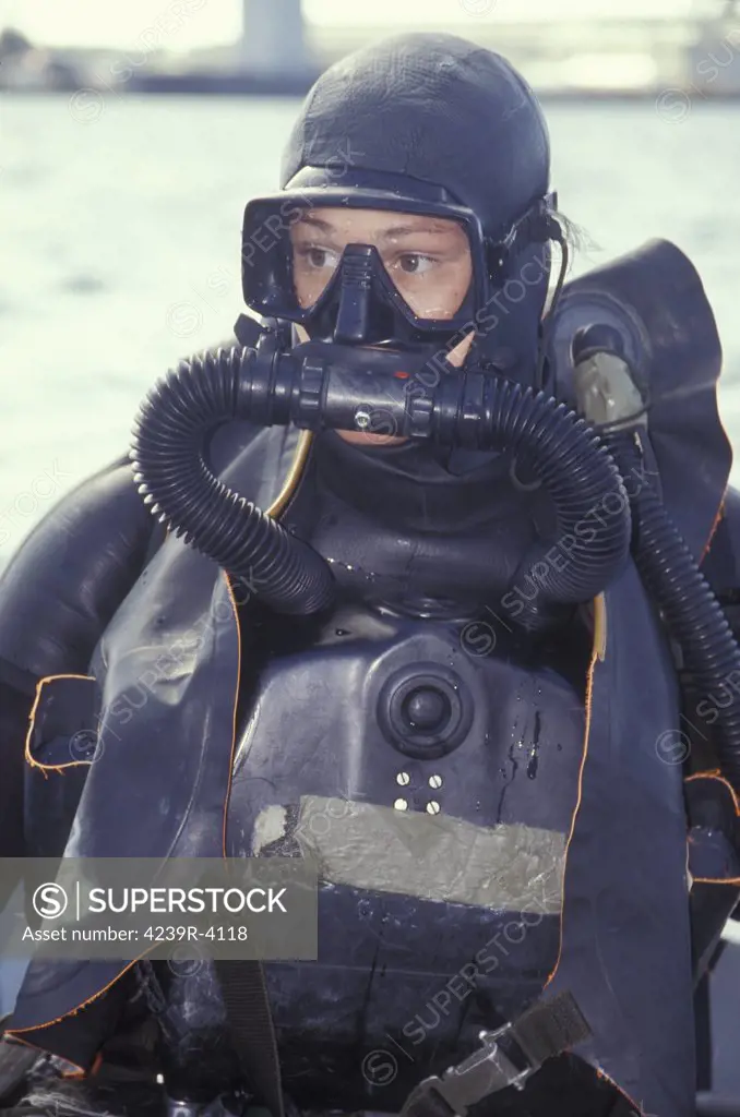 A Navy SEAL combat swimmer on bag breathing and purging all the CO2 from the closed circuit rebreather before commencing a combat navigation swim in Pearl Harbor along the shoreline of Ford Island in Oahu, HI. The combat swimmer is diving a Draeger Lar-V underwater breathing apparatus (UBA) and wearing a Secumar life jacket.