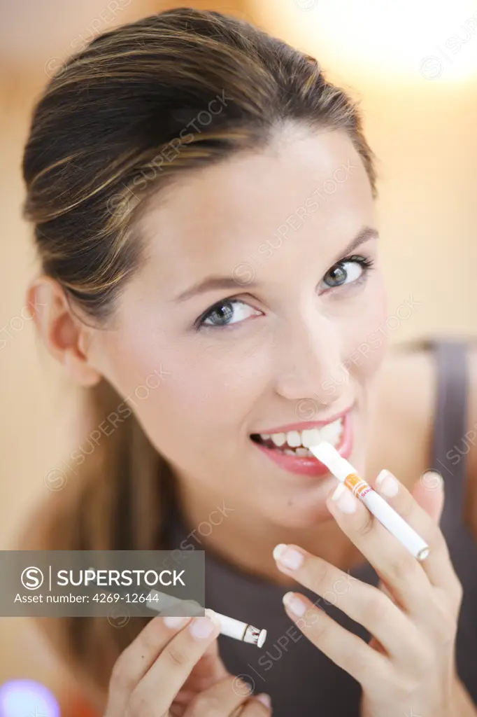 Woman smoking flavored nicotine-free cigarette.