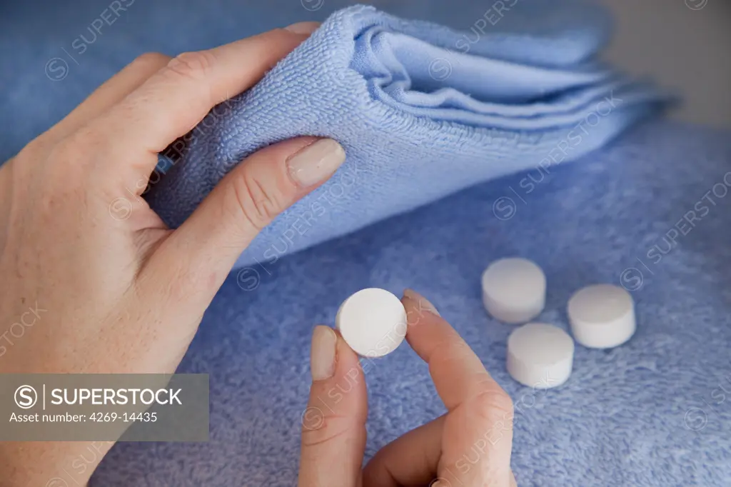 Woman placing mothballs (naphtalene) in her clothes. - SuperStock