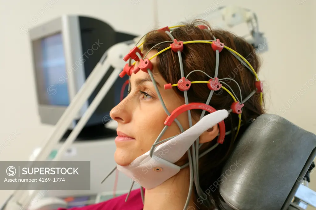 Patient undergoing an electroencephalogram (EEG). The doctor is placing the electrodes on the scalp of the patient according to a determined grid (from 12 to 24 electrodes).