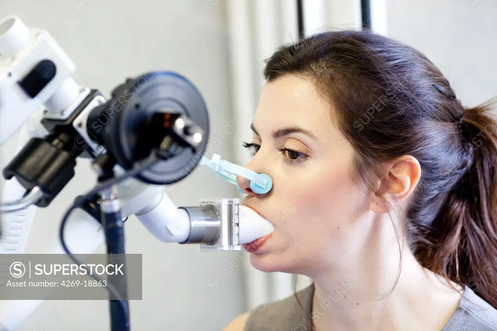 Woman undergoing a body plethysmography. Body plethysmography is a lung function test that measures residual volume, functional residual capacity, and total lung capacity.