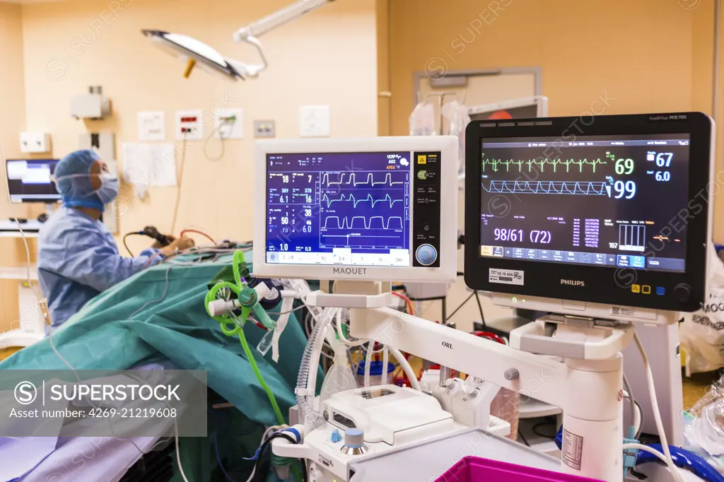 Surgical monitors being used to track the vital signs of a patient during an operation, Limoges hospital, France.