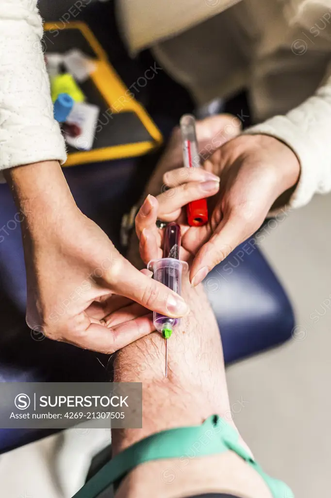 Liberal nurse taking blood sample from a patient.