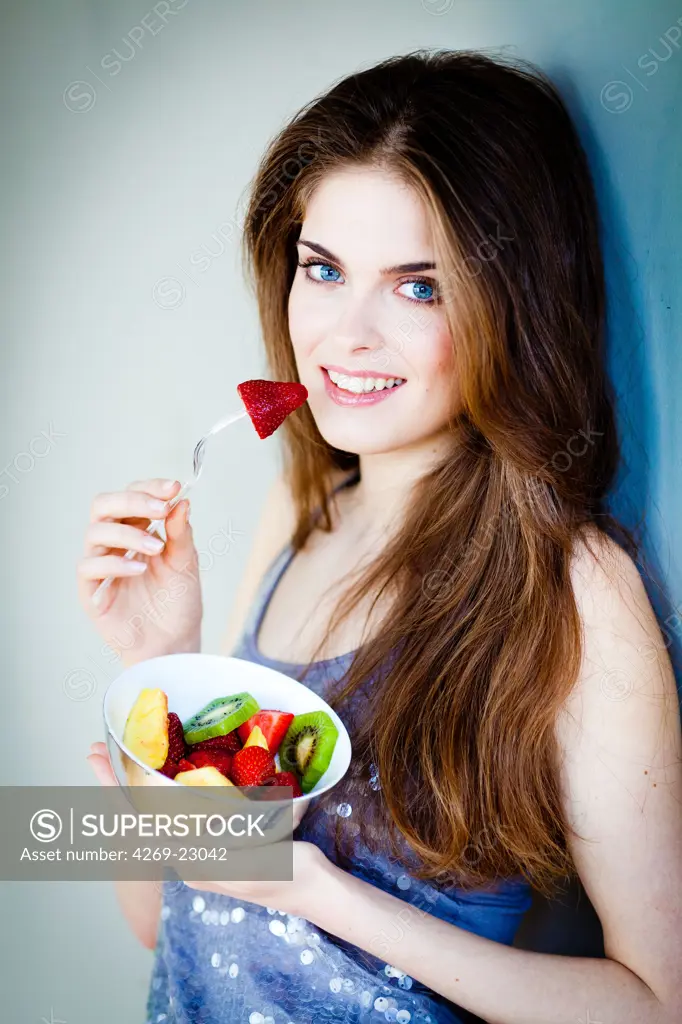 Woman eating a fruit salad.