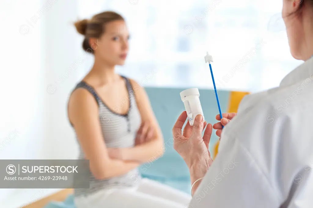 Gynecologist performing a cervical smear or pap test on a teenage patient.