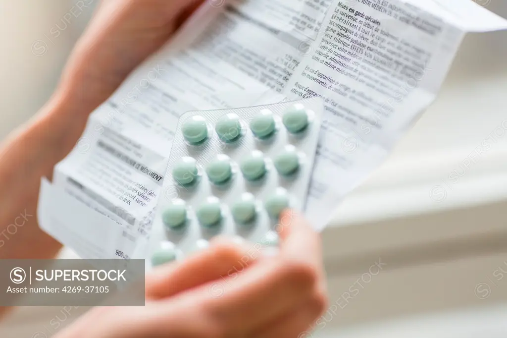 Medicine, Woman reading medicine instruction sheet.