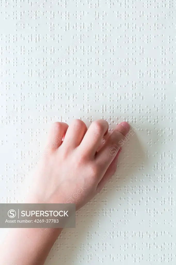 Hands of a blind child reading braille.