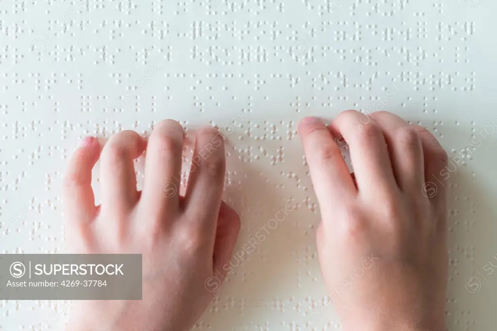 Hands of a blind child reading braille.