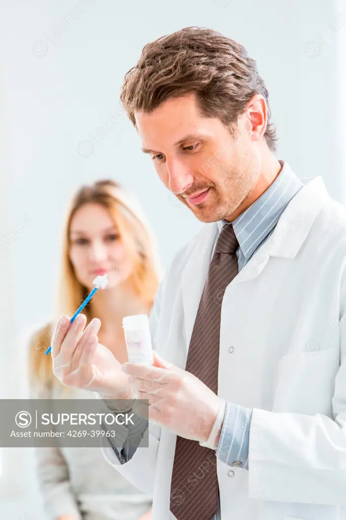 Gynecologist performing a cervical smear or pap test on a female patient.